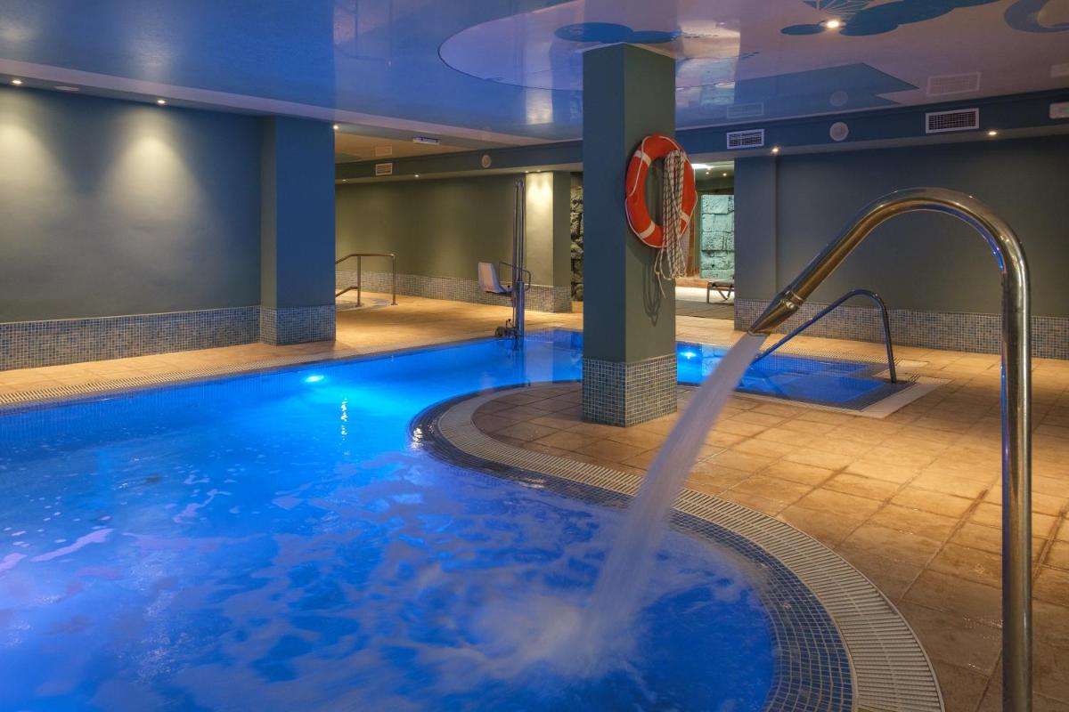 una gran piscina con una fuente de agua en Cabot Cap de Mar Spa, en Cala Bona 21 fotos más