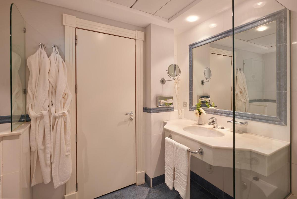 Un baño blanco con lavabo y espejo. en Hipotels Eurotel Punta Rotja Spa-Golf, en Costa des Pins