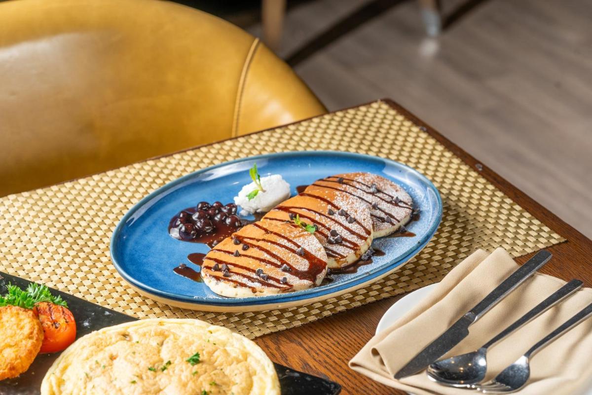 a blue plate with hot dogs and other food on a table at Holiday Inn Kolkata Airport by IHG in Kolkata