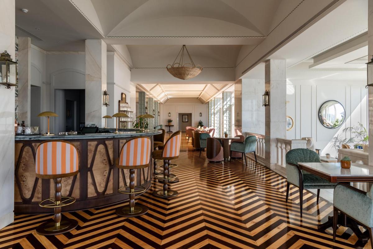 um quarto com um bar com cadeiras e mesas em Reid's Palace, A Belmond Hotel, Madeira no Funchal