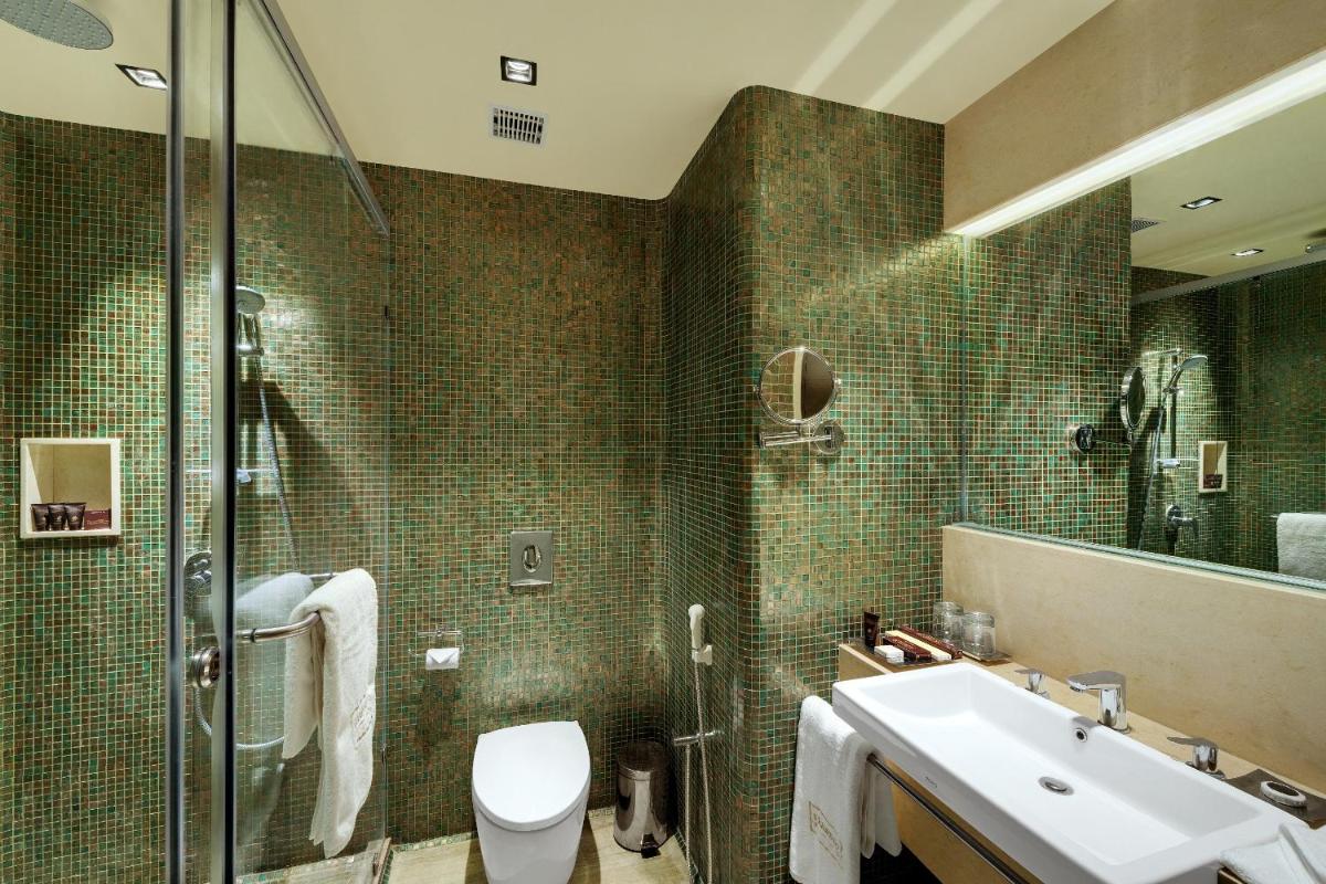 a bathroom with a toilet and a sink and a shower at Wyndham Ahmedabad Shela in Ahmedabad
