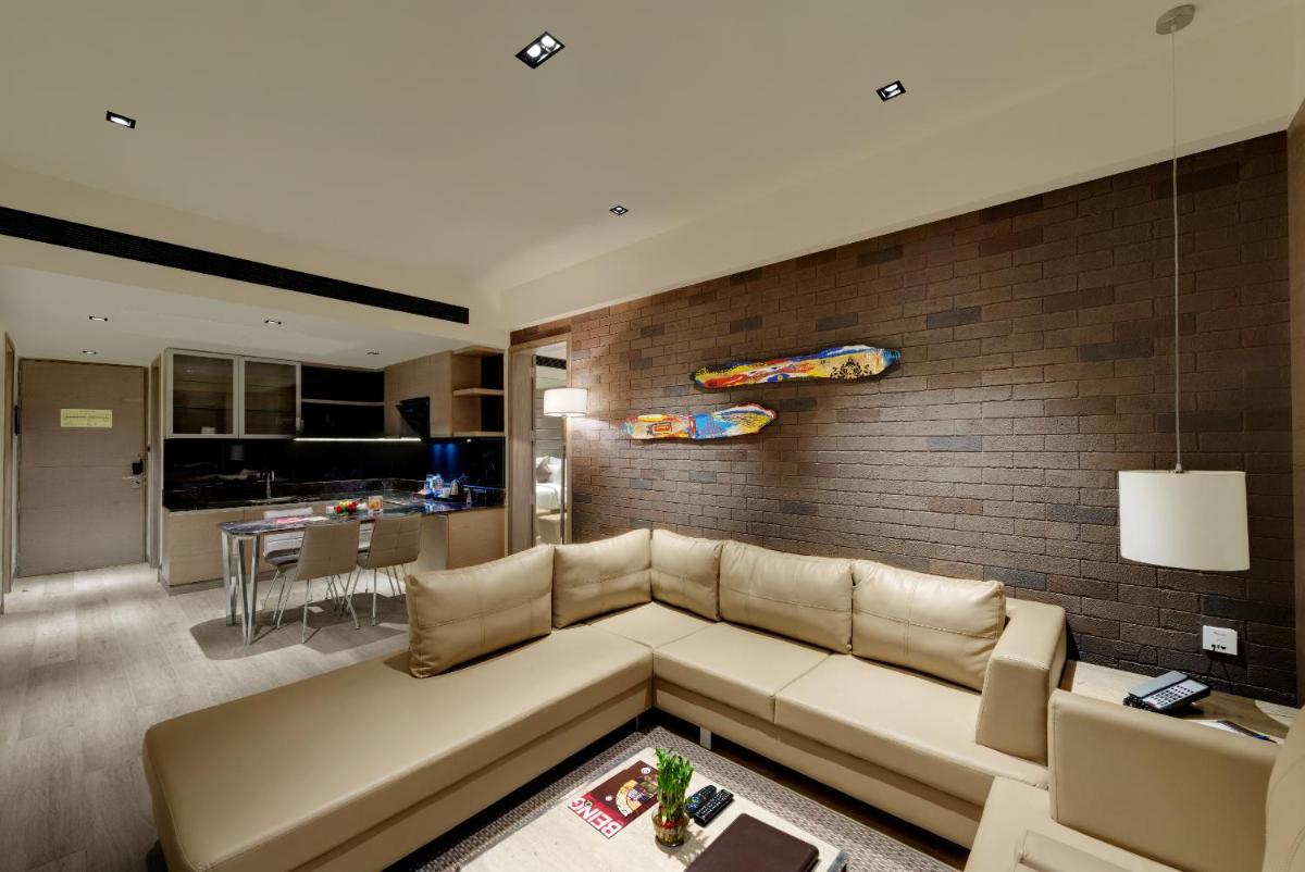 a living room with a couch and a brick wall at Wyndham Ahmedabad Shela in Ahmedabad