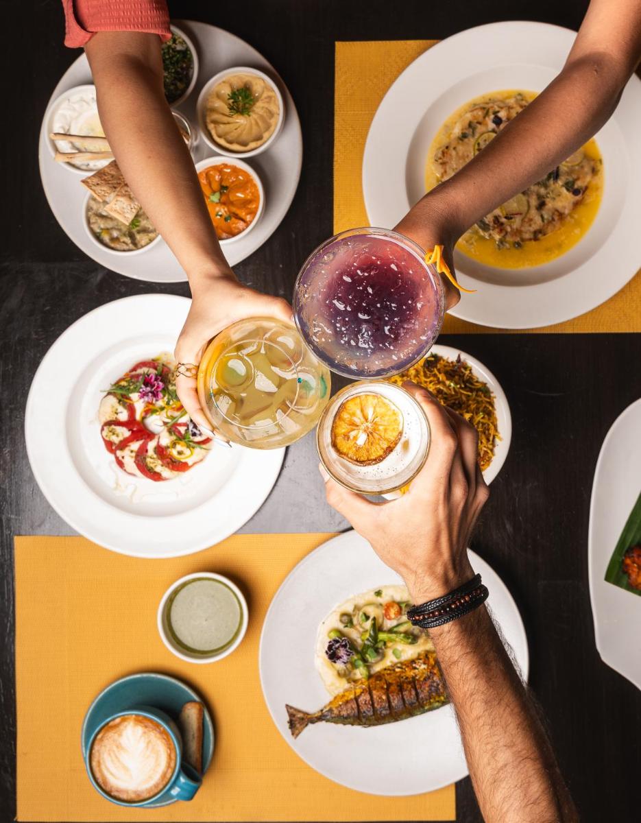 a group of people holding up plates of food at Novotel Kolkata Hotel and Residences in Kolkata a group of people holding up plates of food at Novotel Kolkata Hotel and Residences in Kolkata