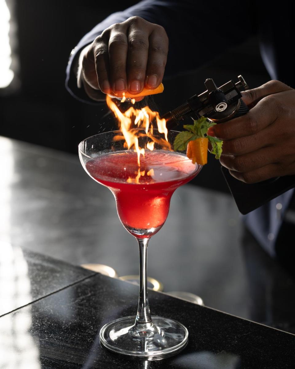 a bartender is making a cocktail in a martini glass at Novotel Kolkata Hotel and Residences in Kolkata a bartender is making a cocktail in a martini glass at Novotel Kolkata Hotel and Residences in Kolkata