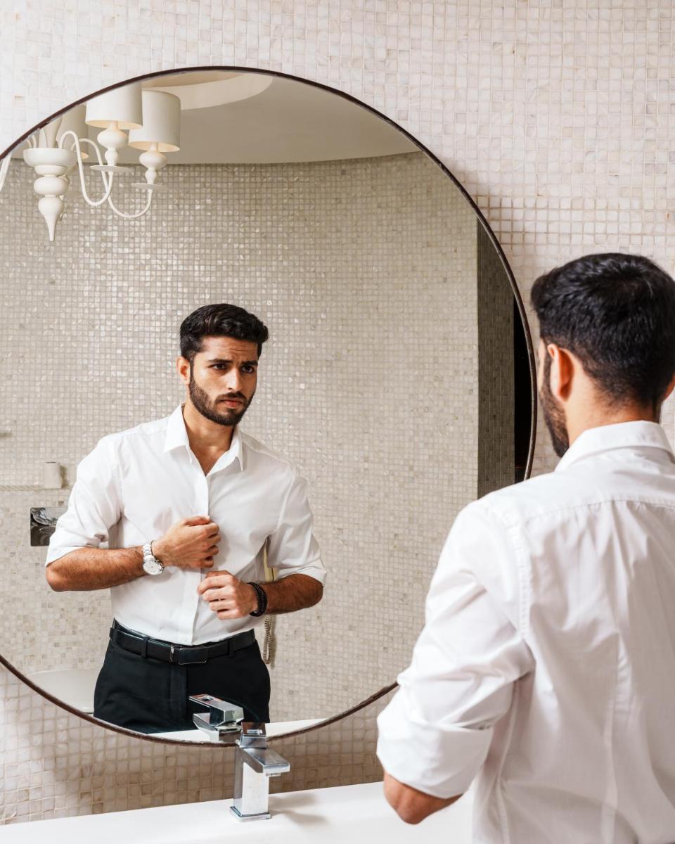 a man looking at his reflection in a mirror at Novotel Kolkata Hotel and Residences in Kolkata a man looking at his reflection in a mirror at Novotel Kolkata Hotel and Residences in Kolkata
