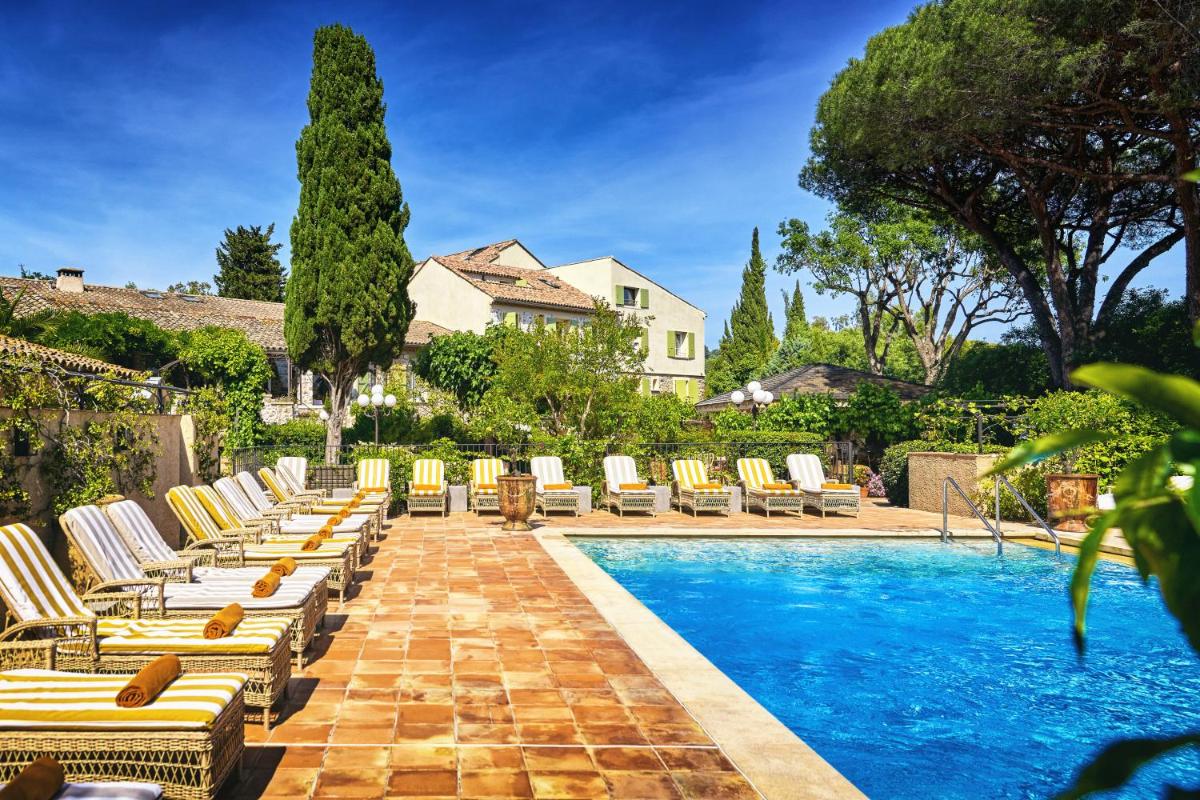 une piscine avec des chaises longues à côté d'une maison dans l'établissement La Ferme D'Augustin, à Saint-Tropez