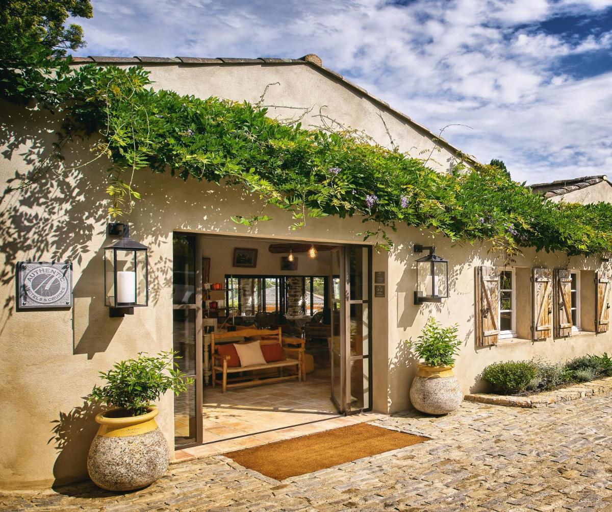 un bâtiment avec des plantes sur le côté dans l'établissement La Ferme D'Augustin, à Saint-Tropez