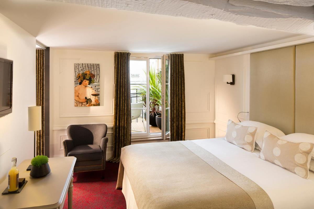 une chambre d'hôtel avec un lit, un bureau et une chaise dans l'établissement Hôtel Molière, à Paris une chambre d'hôtel avec un lit, un bureau et une chaise dans l'établissement Hôtel Molière, à Paris