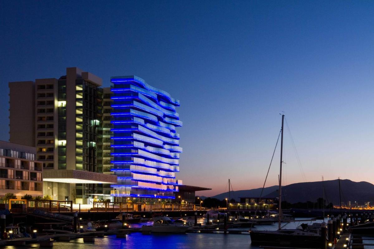 um edifício alto com luzes azuis numa marina à noite em Troia Design Hotel em Tróia