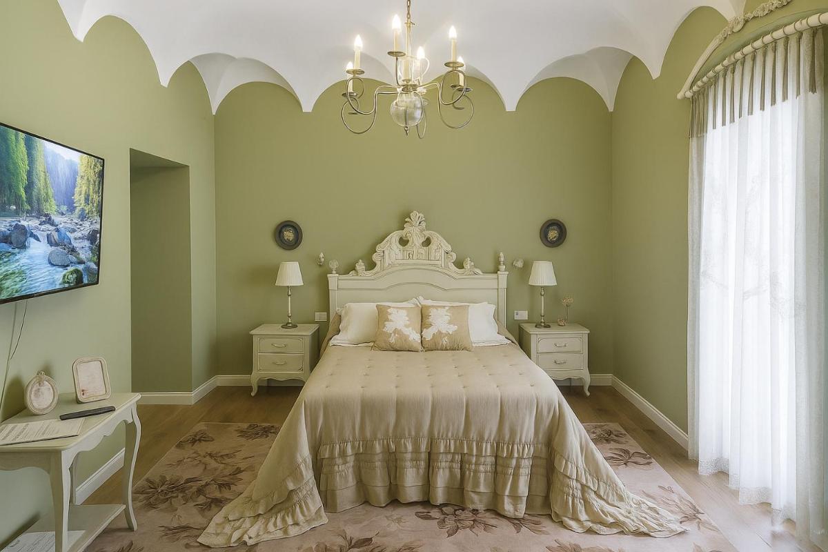 Un dormitorio con una cama grande y una lámpara de araña. en Hotel Boutique iulia 5 Estrellas, en Zafra