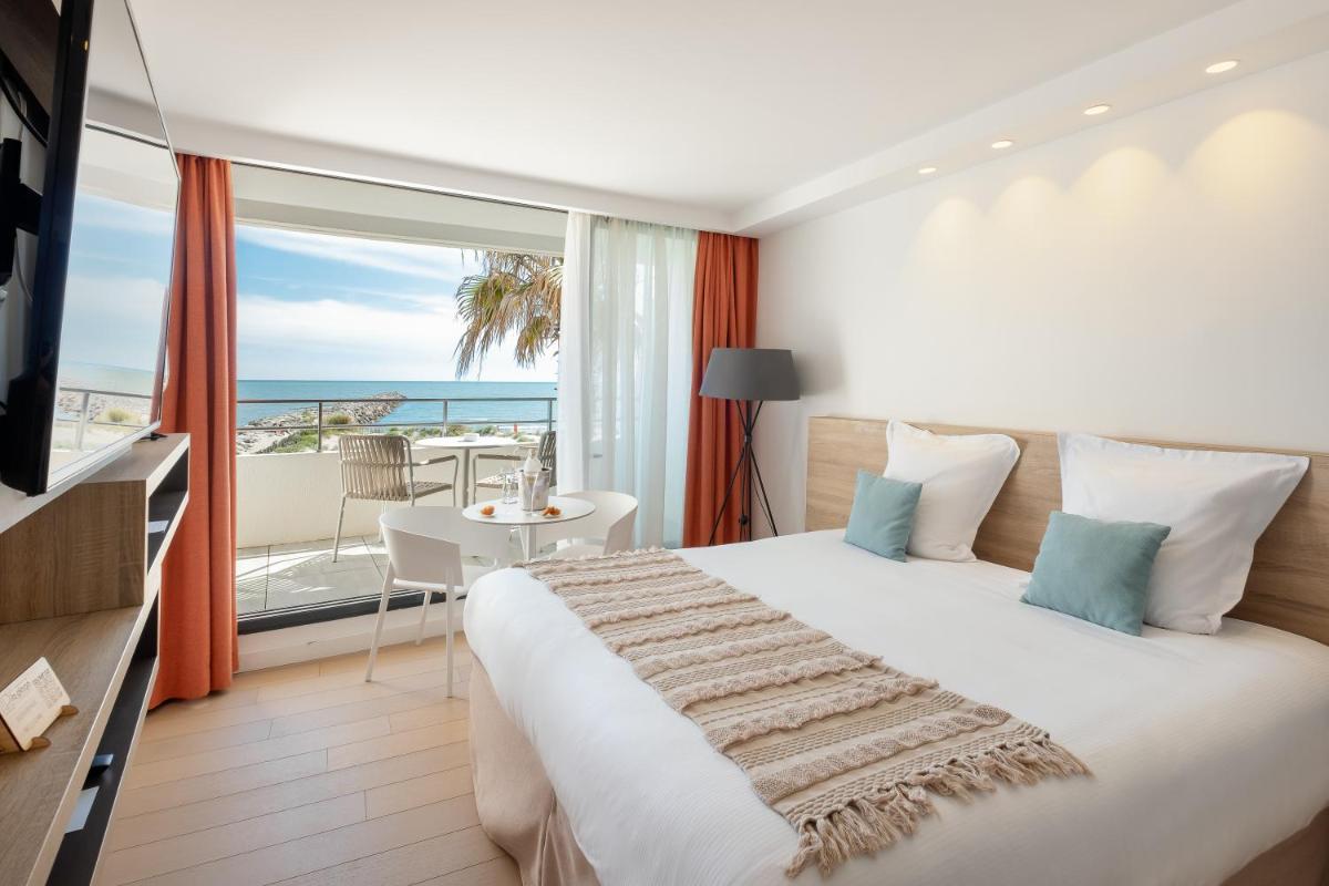 une chambre avec un lit et un balcon avec l'océan dans l'établissement Hôtel La Plage 5 étoiles La Grande Motte, à La Grande Motte