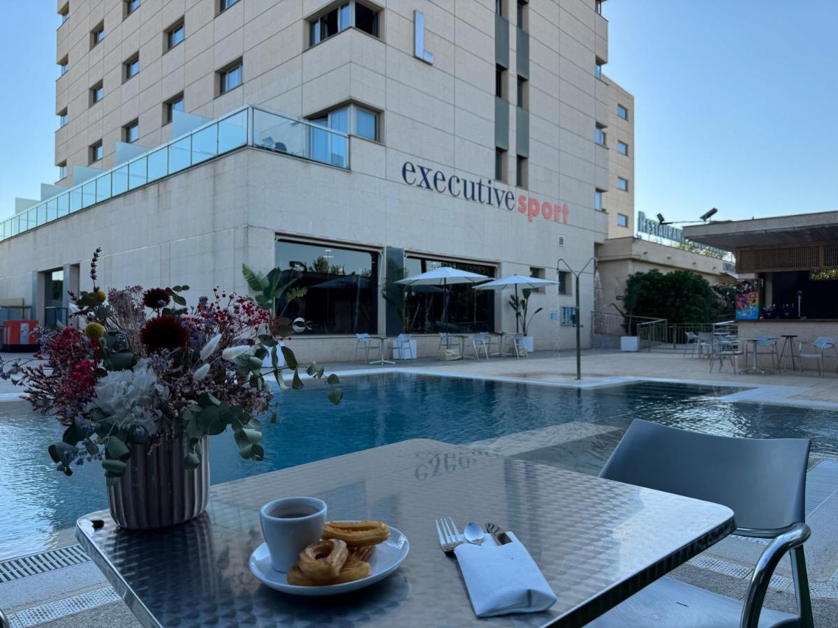 Una mesa con un plato de pasteles al lado de un edificio. en Executive Sport, en Totana