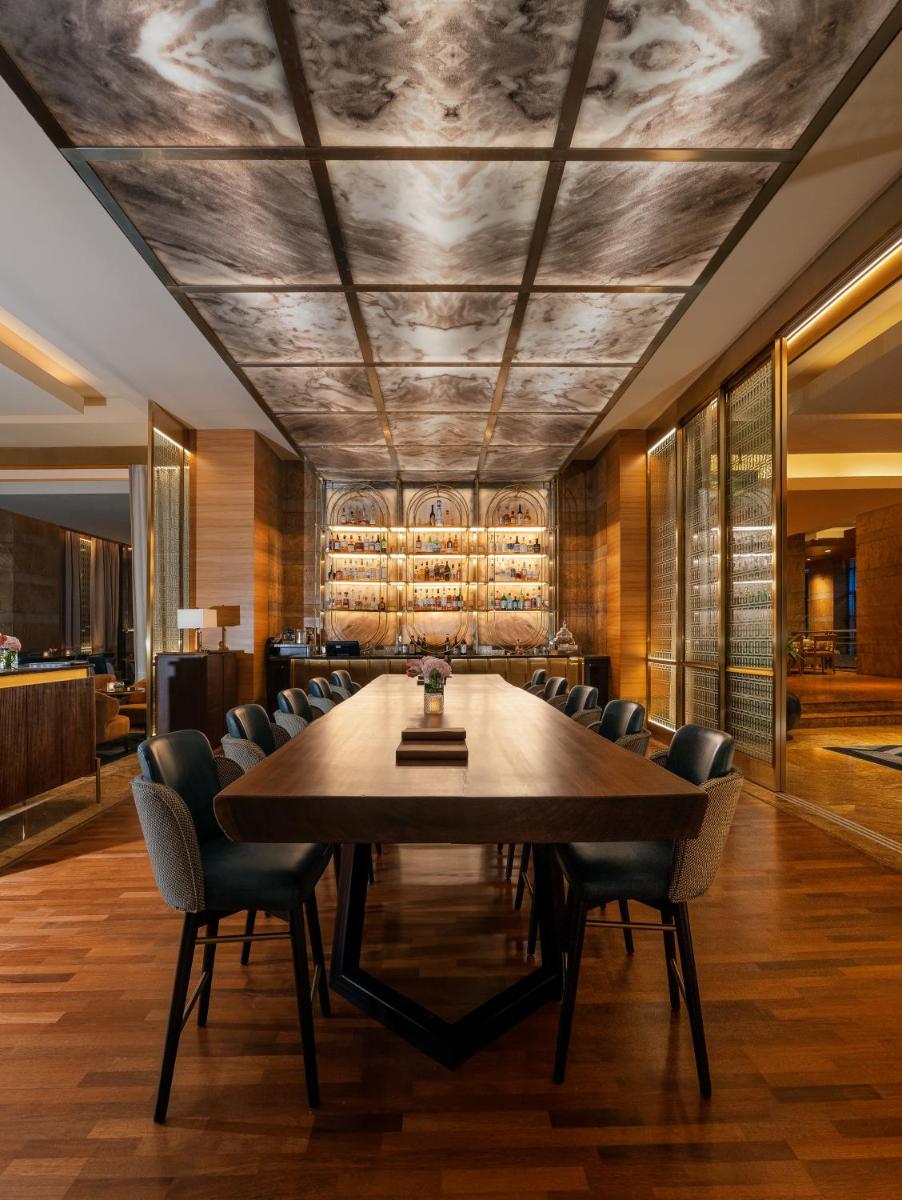 a dining room with a large wooden table and chairs at Grand Hyatt Mumbai Hotel and Residences in Mumbai