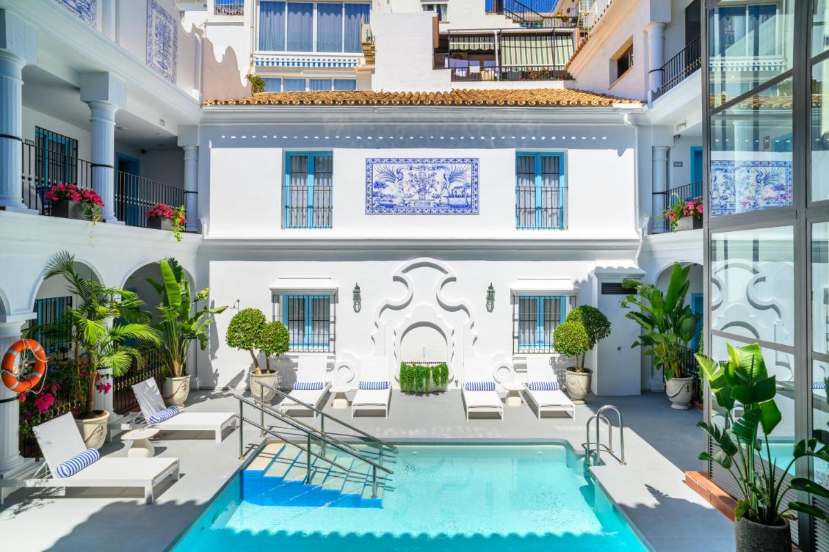 un patio de apartamentos con piscina y sillas en Hotel La Fonda, en Benalmádena