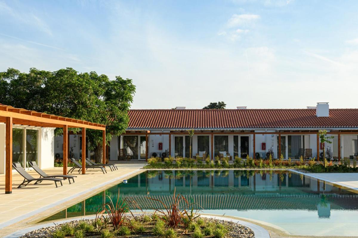 uma piscina em frente a um prédio em Sorraia Hotel Rural em Santa Justa