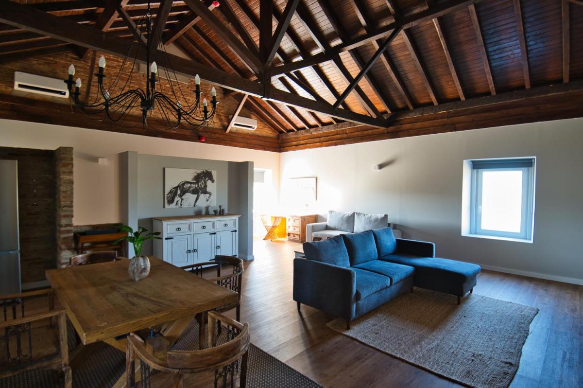 uma sala de estar com um sofá azul e uma mesa em Sorraia Hotel Rural em Santa Justa