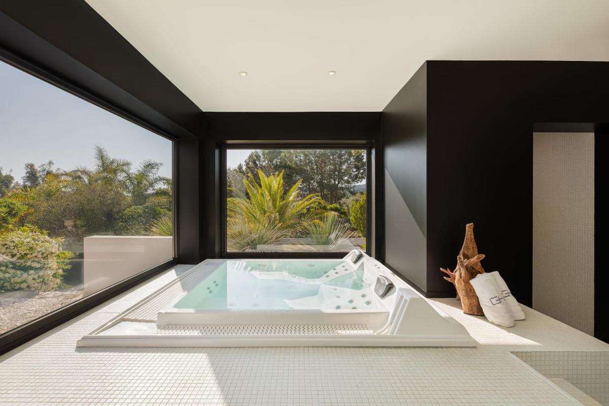 une salle de bain avec une baignoire et une grande fenêtre dans l'établissement Grand Hotel Du Golfe - Spa & Restaurant, à Collioure