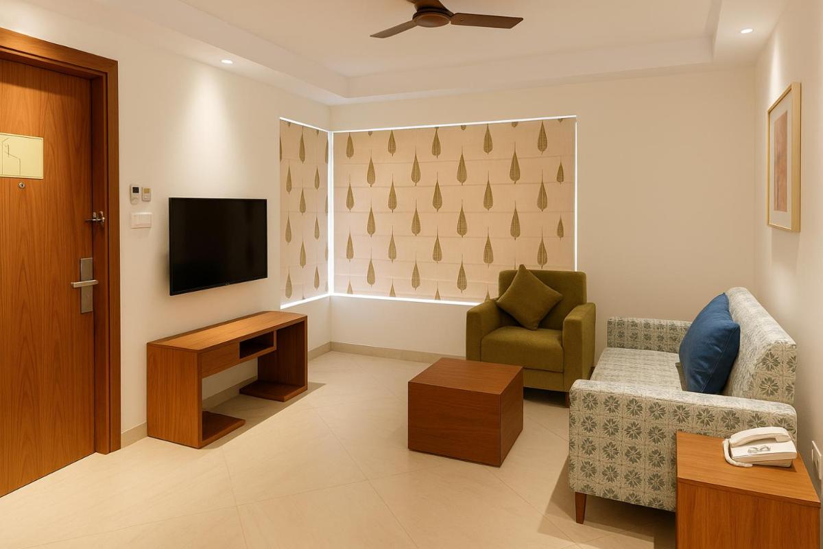a living room with a tv and a couch and a chair at Hawthorn Suites by Wyndham Dwarka in Dwarka a living room with a tv and a couch and a chair at Hawthorn Suites by Wyndham Dwarka in Dwarka