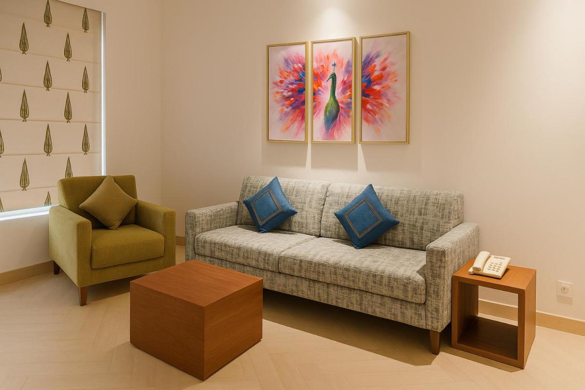a living room with a couch and a chair at Hawthorn Suites by Wyndham Dwarka in Dwarka a living room with a couch and a chair at Hawthorn Suites by Wyndham Dwarka in Dwarka
