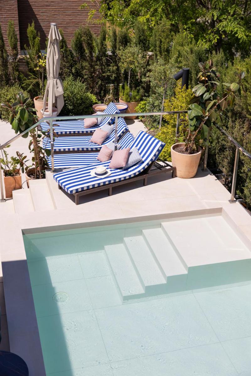 Una toalla azul y blanca en una silla junto a una piscina. en Cavalta Boutique Hotel - Small Luxury Hotels, en Sevilla
