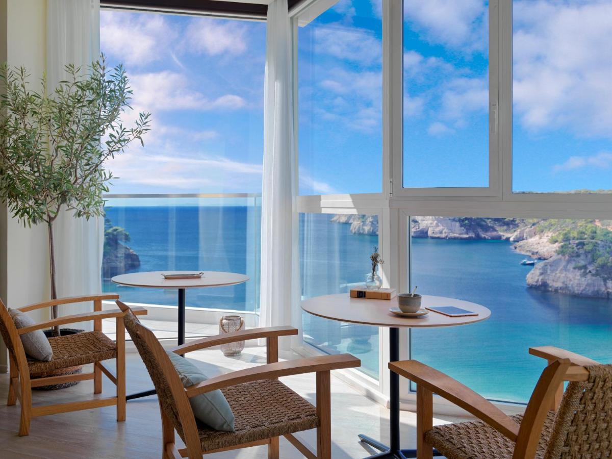 Habitación con mesas, sillas y vistas al océano. en Meliá Cala Galdana, en Cala Galdana