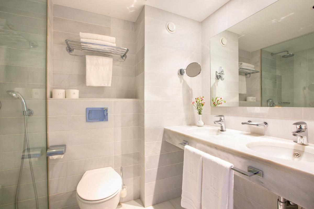 Un baño con inodoro, lavabo y ducha. en Hipotels Hipocampo Playa, en Cala Millor