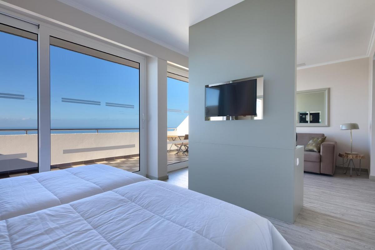 Uma televisão e/ou sistema de entretenimento em Hotel Orca Praia