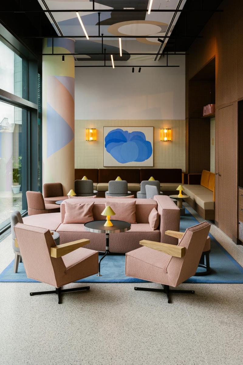 ein Wartezimmer mit Sofas und Stühlen in einem Gebäude in der Unterkunft Kimpton Main Frankfurt by IHG in Frankfurt am Main