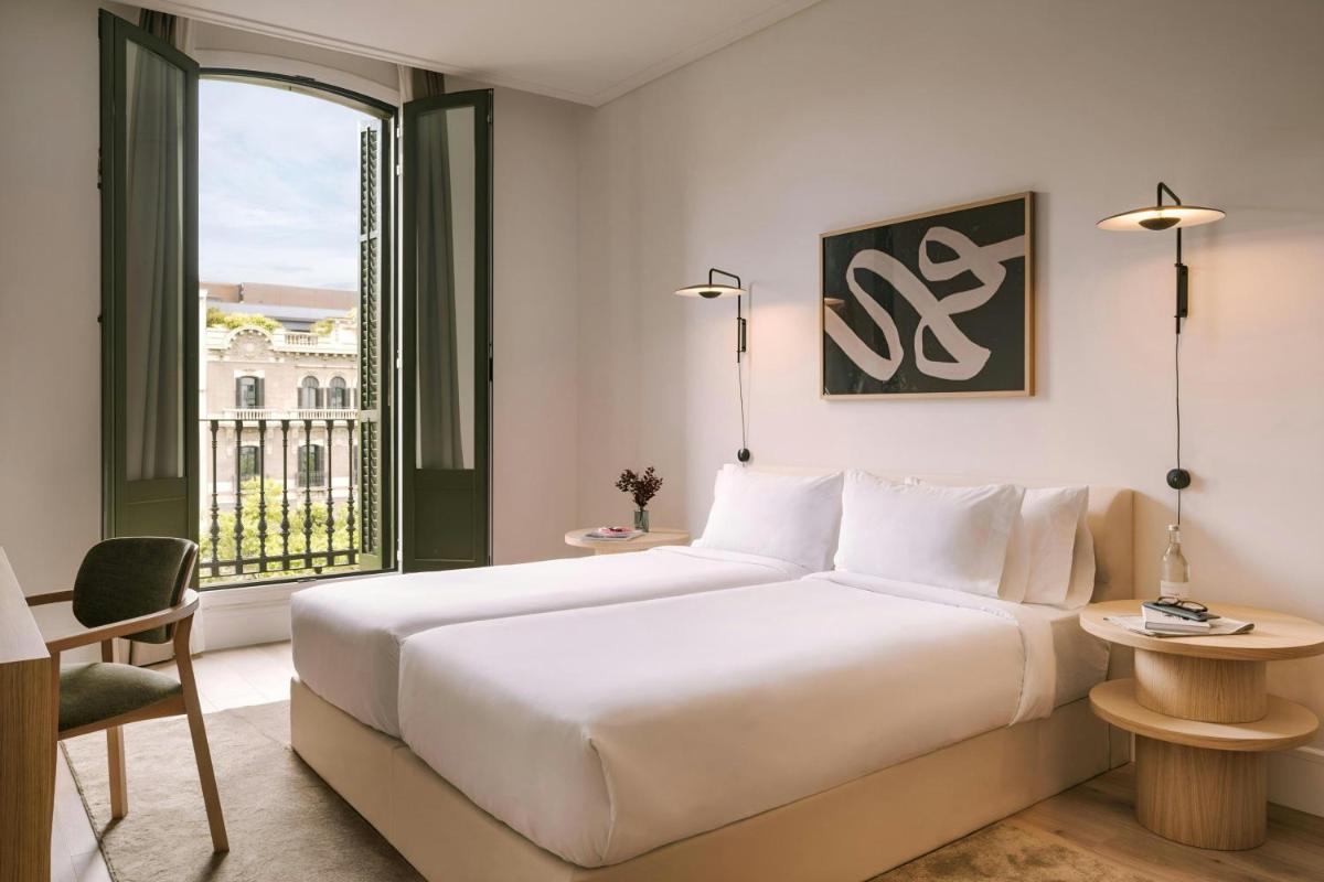 Un dormitorio con una gran cama blanca y una ventana. en Paseo de Gracia Hotel, Sonder by Marriott Bonvoy, en Barcelona