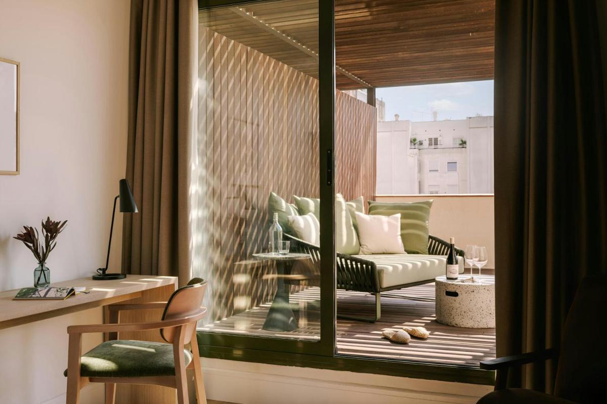 Habitación con balcón, sofá y mesa. en Paseo de Gracia Hotel, Sonder by Marriott Bonvoy, en Barcelona