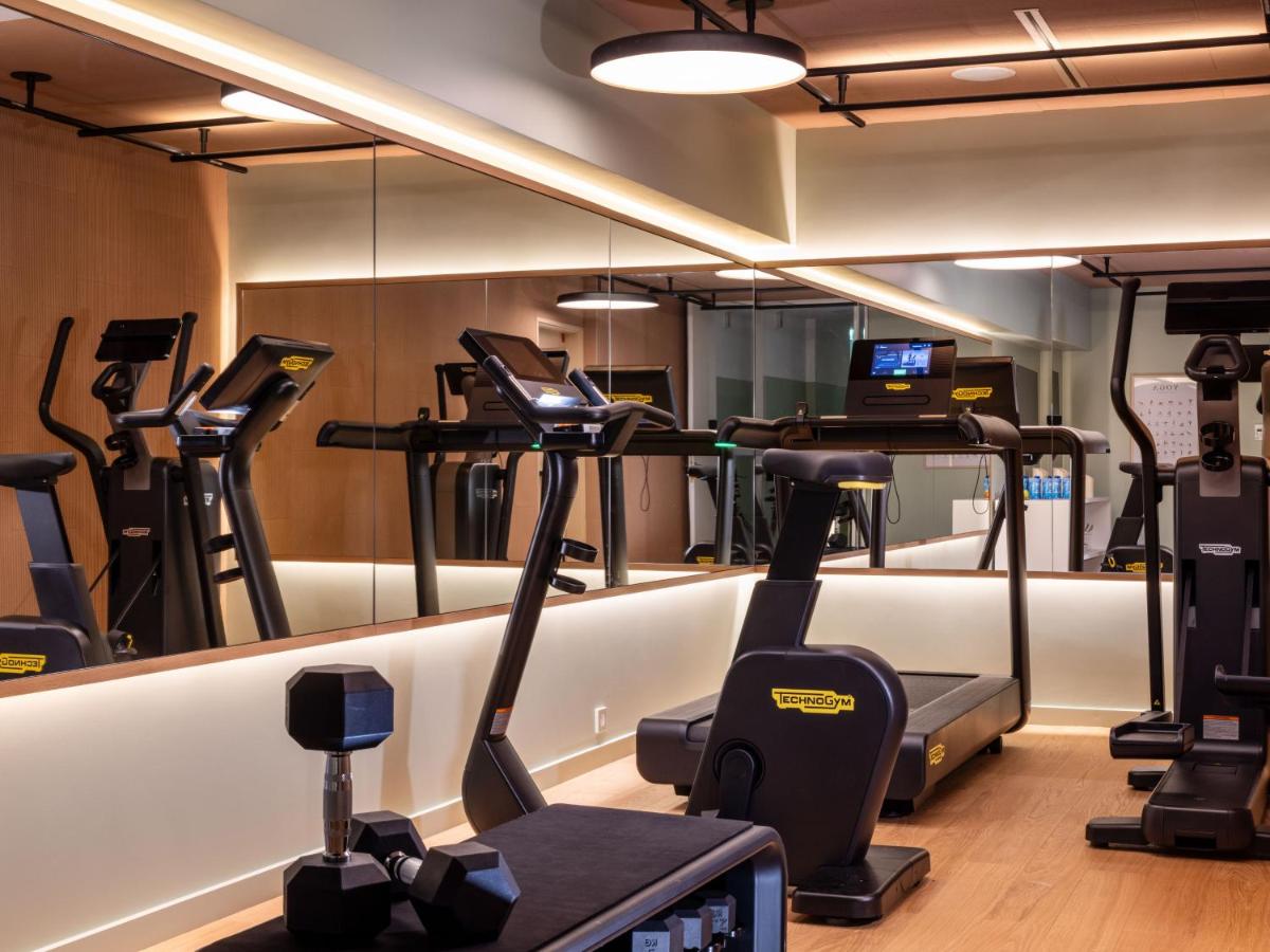 une salle de sport avec tapis de course et machines elliptiques dans l'établissement Hôtel De Sers Champs Elysées Paris, à Paris