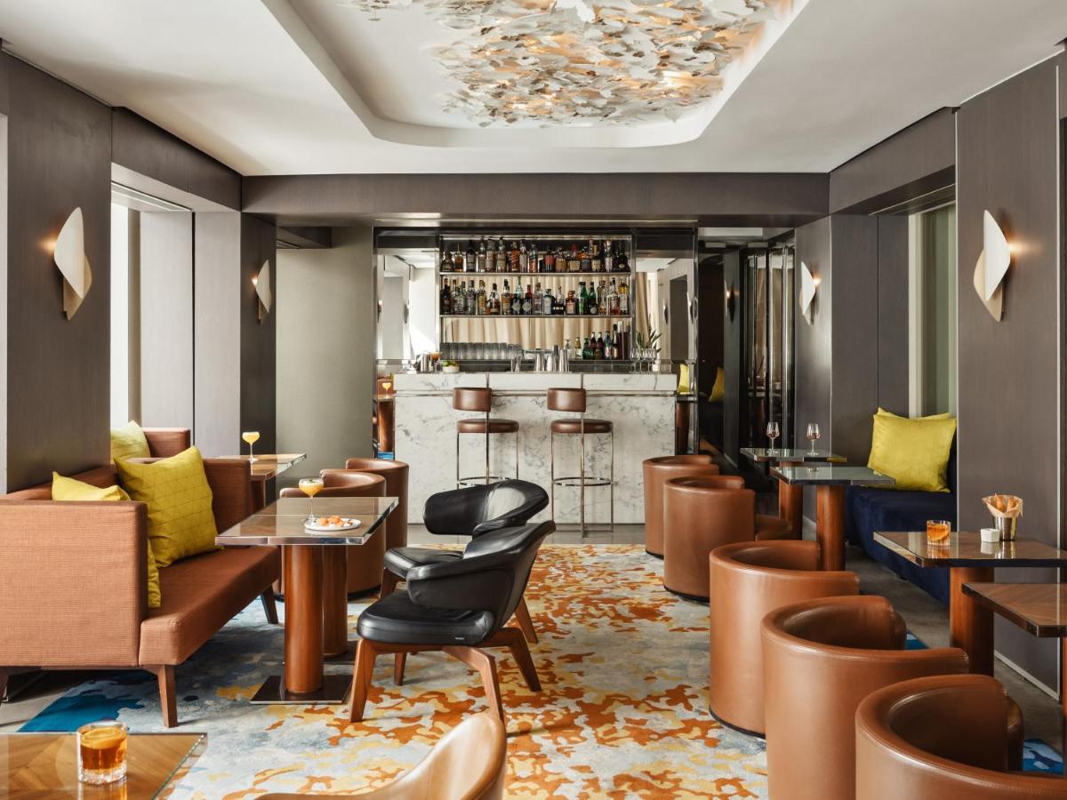 un hall d'hôtel avec des tables, des chaises et un bar dans l'établissement Hôtel De Sers Champs Elysées Paris, à Paris
