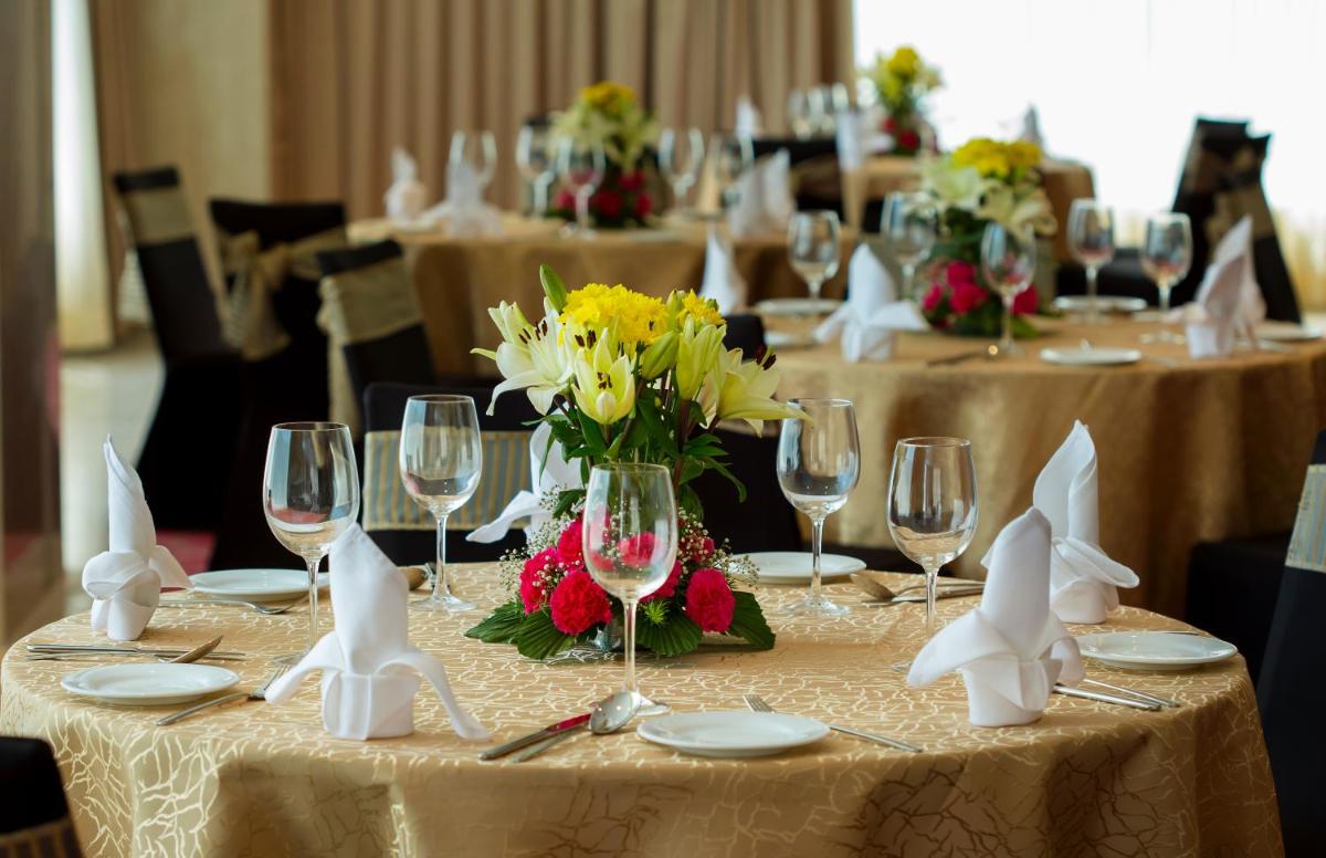 a group of tables with wine glasses and flowers at Mercure Hyderabad KCP Banjara Hills, An Accor Hotel in Hyderabad