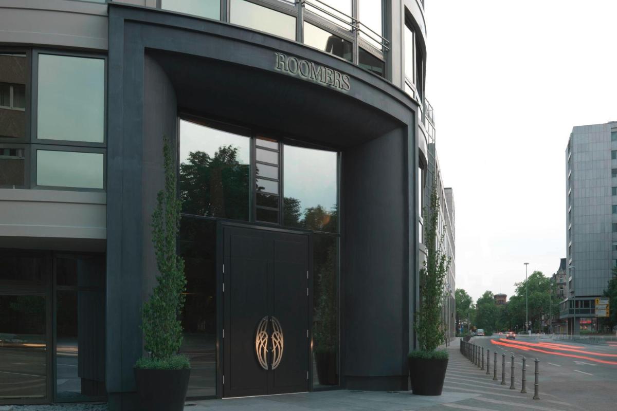 einen Eingang zu einem Gebäude mit einem Schild darauf in der Unterkunft Roomers Frankfurt Central, Autograph Collection in Frankfurt am Main einen Eingang zu einem Gebäude mit einem Schild darauf in der Unterkunft Roomers Frankfurt Central, Autograph Collection in Frankfurt am Main