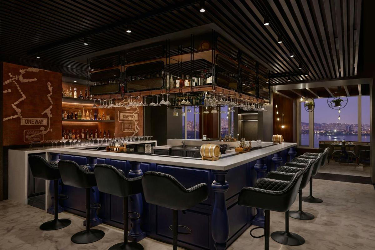 a bar with blue bar stools in a restaurant at The Westin Mumbai Powai Lake in Mumbai