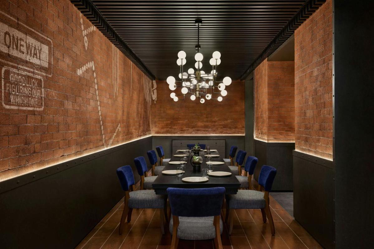 a dining room with a long table and blue chairs at The Westin Mumbai Powai Lake in Mumbai