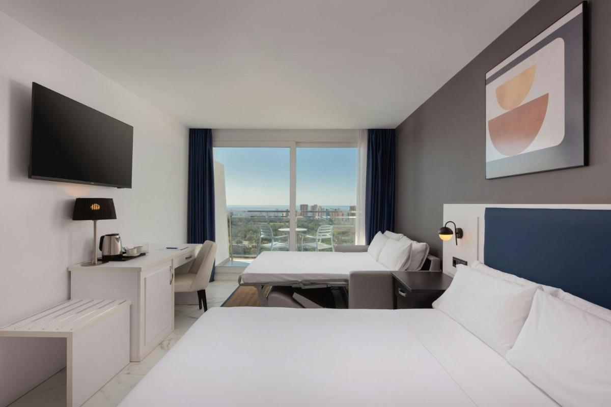 una habitación de hotel con una cama y un escritorio en Four Points by Sheraton Costa Blanca Resort, en Benidorm