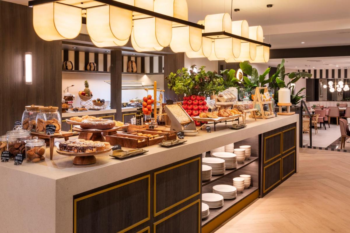 Una línea de buffet con mucha comida en exhibición en Catalonia Plaza España Hotel & Spa, en Madrid