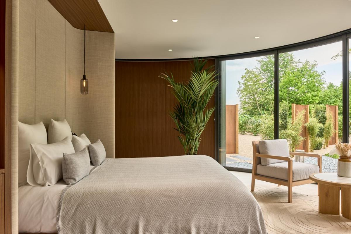 une chambre avec un lit blanc et une chaise dans l'établissement Maison Zugno Hôtel & Spa, à Barretaine 38 autres photos