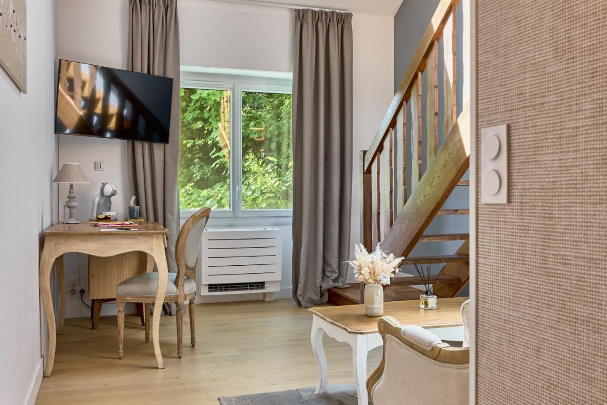 un salon avec un bureau, une fenêtre et un escalier dans l'établissement Maison Zugno Hôtel & Spa, à Barretaine