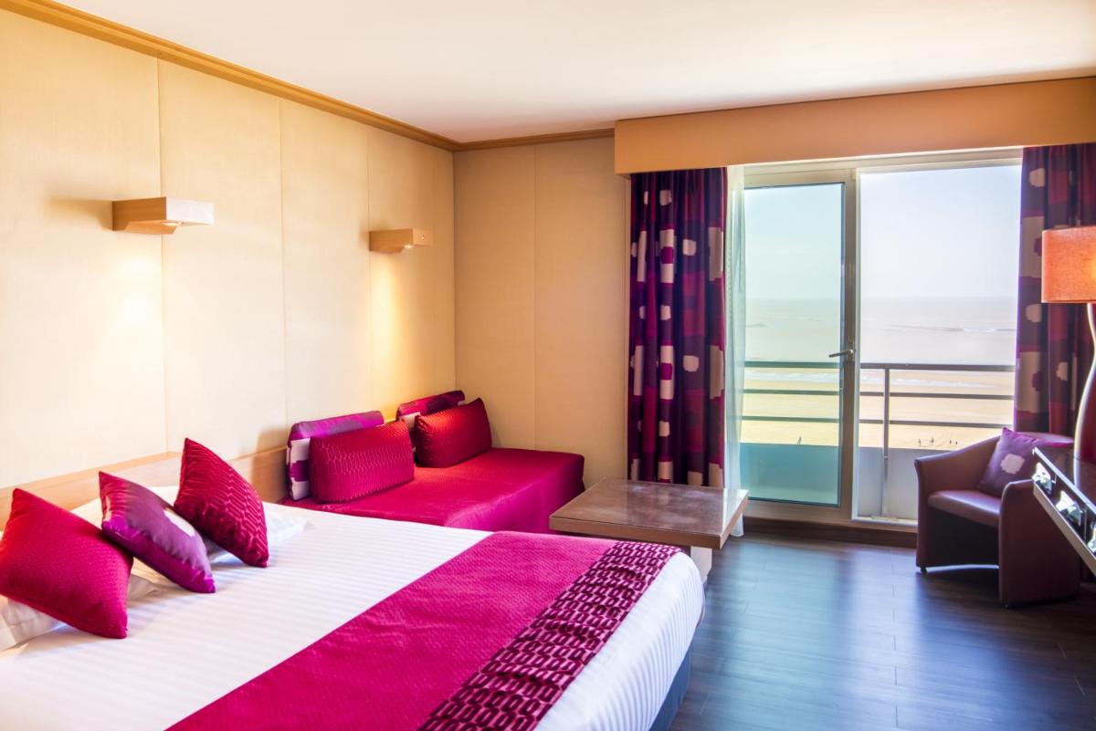 une chambre d'hôtel avec un lit, un canapé et une fenêtre dans l'établissement Hôtel Spa du Beryl St Brévin l'Océan, à Saint-Brévin-les-Pins