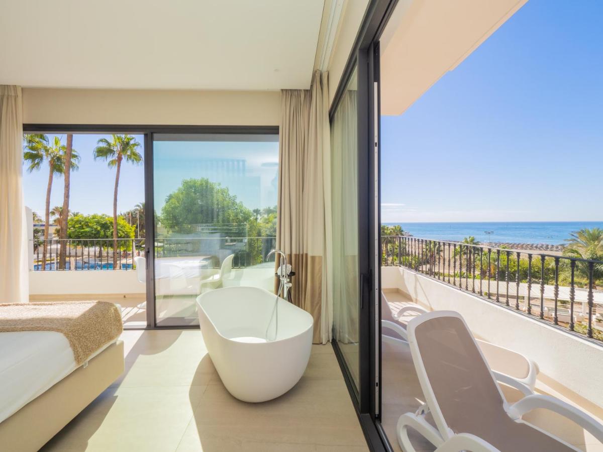Un dormitorio con bañera y balcón con vista al mar. en Comfy Studios Hotel, en Benalmádena