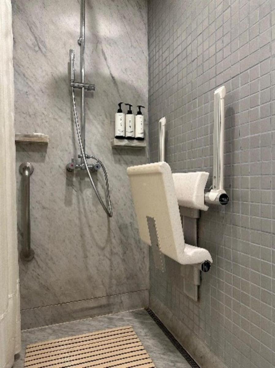 a bathroom with a shower with a shower seat at Crowne Plaza Today Gurugram by IHG in Gurgaon