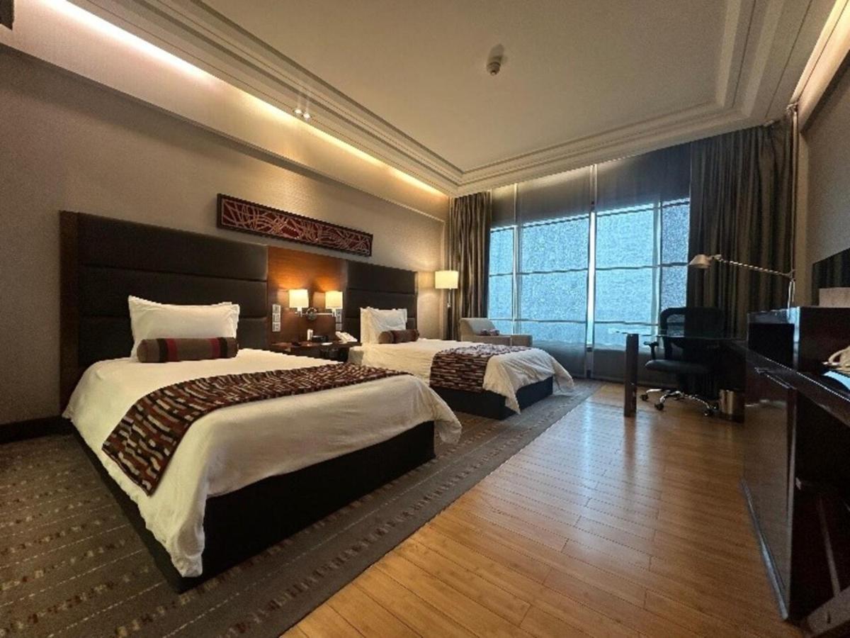 a large hotel room with two beds and a piano at Crowne Plaza Today Gurugram by IHG in Gurgaon