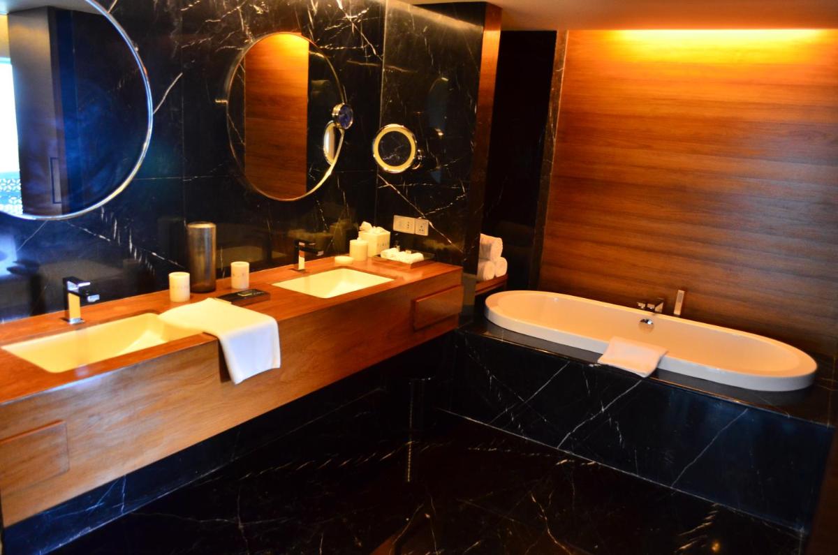 a bathroom with two sinks and a tub and a mirror at The Park Hyderabad, Banjara Hills near Hussain Sagar Lake in Hyderabad a bathroom with two sinks and a tub and a mirror at The Park Hyderabad, Banjara Hills near Hussain Sagar Lake in Hyderabad