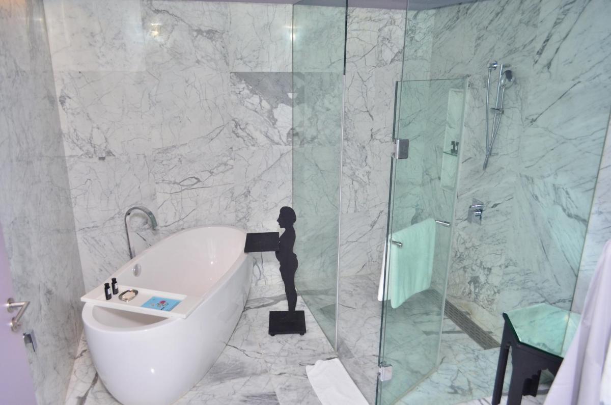 a bathroom with a tub and a glass shower at The Park Hyderabad, Banjara Hills near Hussain Sagar Lake in Hyderabad a bathroom with a tub and a glass shower at The Park Hyderabad, Banjara Hills near Hussain Sagar Lake in Hyderabad