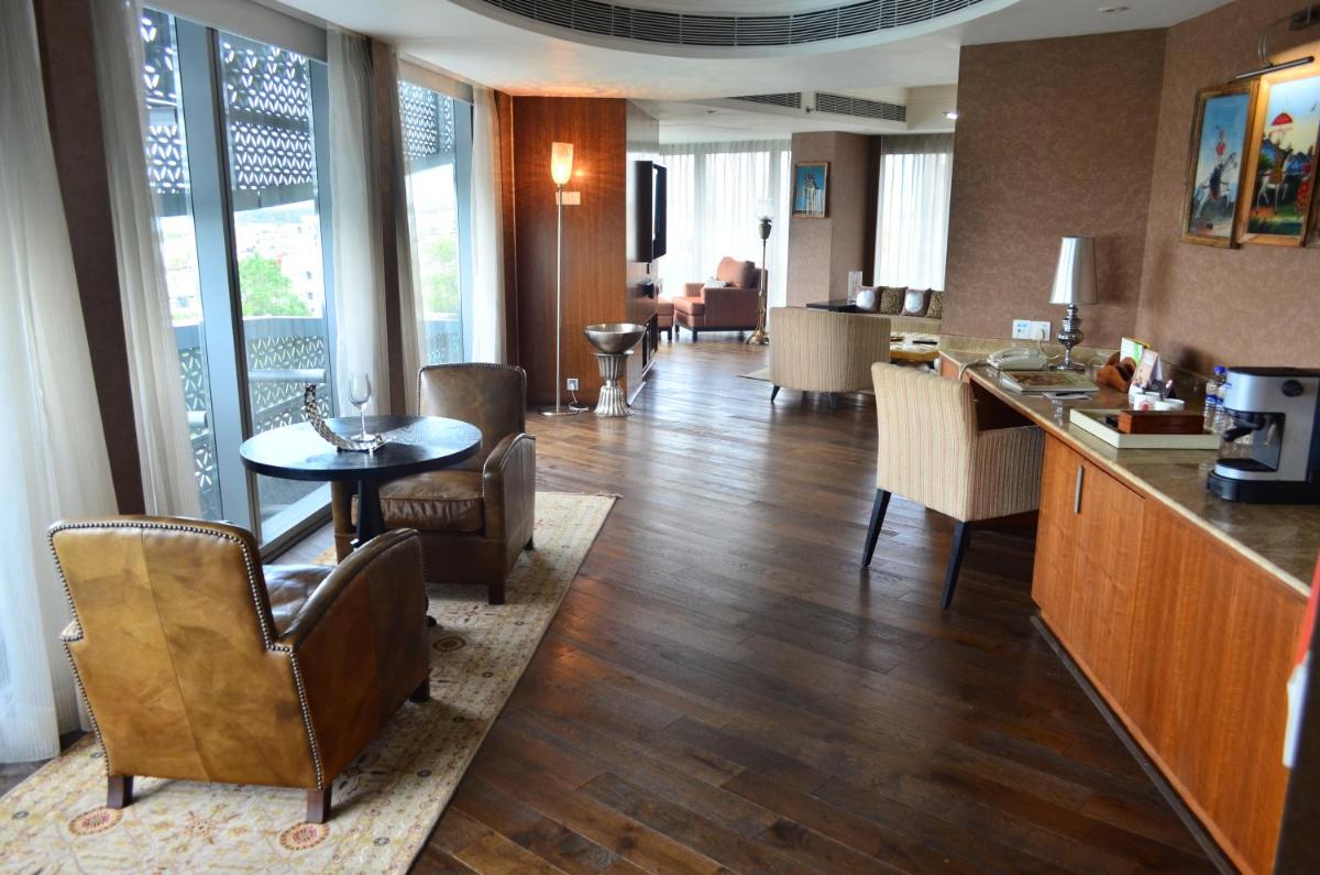 a living room with a kitchen and a table and chairs at The Park Hyderabad, Banjara Hills near Hussain Sagar Lake in Hyderabad a living room with a kitchen and a table and chairs at The Park Hyderabad, Banjara Hills near Hussain Sagar Lake in Hyderabad