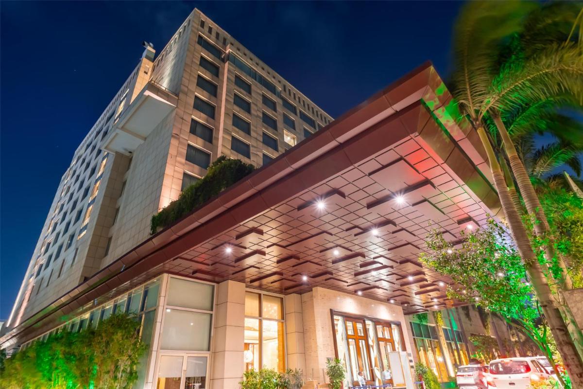 a building with a palm tree in front of it at Radisson Blu Hotel, Nagpur in Nagpur