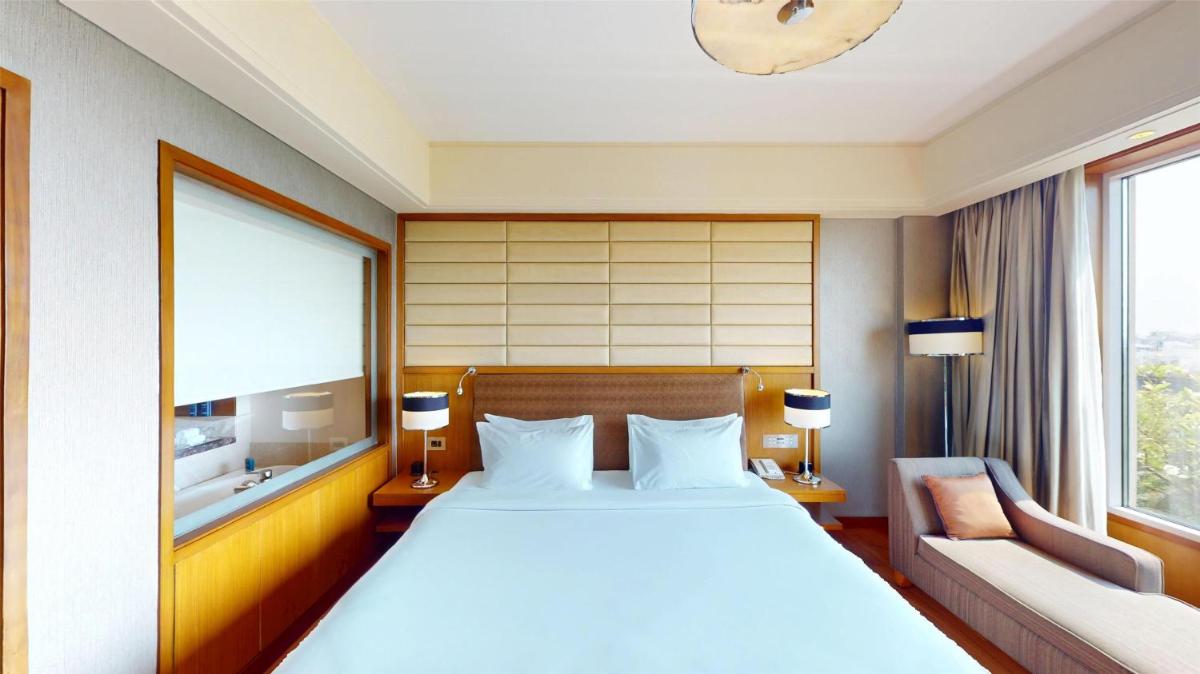 a hotel room with a large bed and a couch at Radisson Blu Hotel, Nagpur in Nagpur