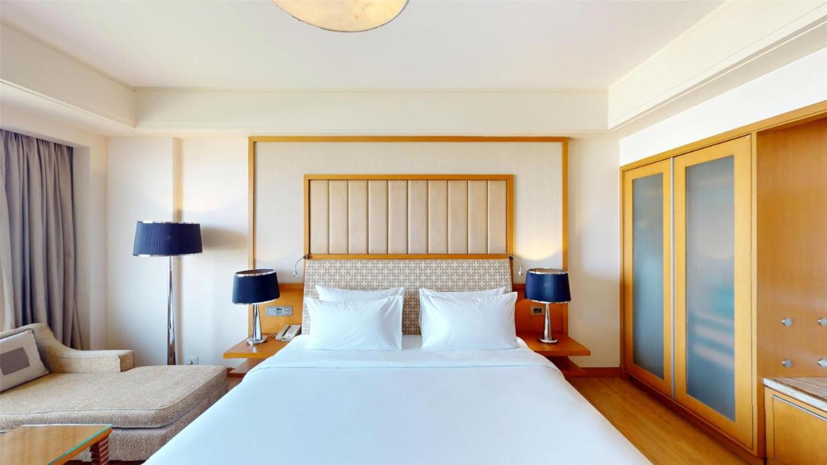 a bedroom with a large white bed and a couch at Radisson Blu Hotel, Nagpur in Nagpur